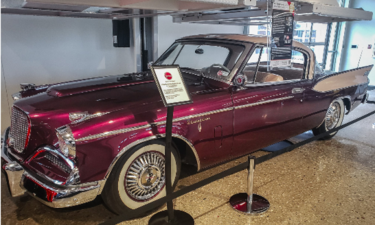 Photo of a red vintage luxury car on display.