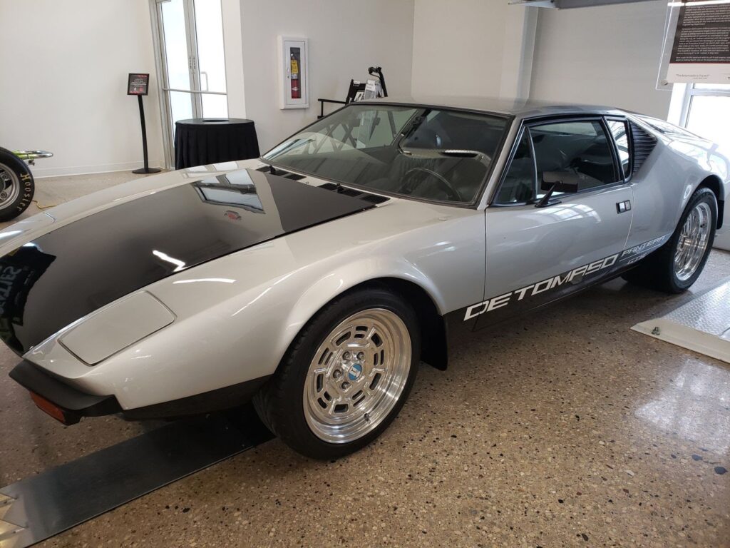 Admire the sleek DeTomaso Pantera sports car in silver, a 1970s icon. (78 characters)
