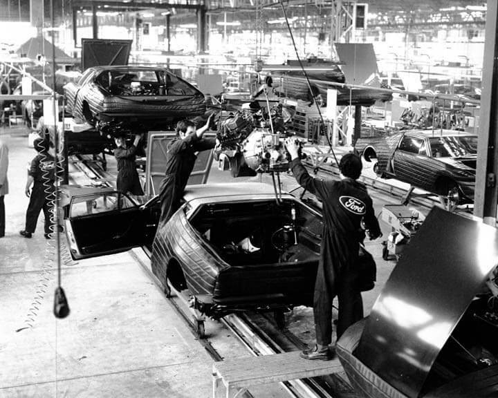 Step into the past with this vintage Ford assembly line photo, showcasing early car manufacturing. (93 characters)