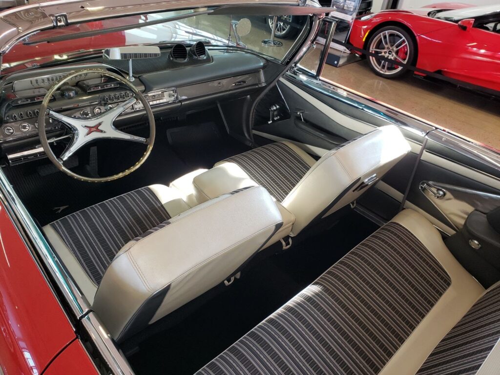 A half-scale Ferrari Formula 1 race car sculpted from dark chocolate sits on display. Its sleek red and black body, accented with white highlights, mimics a real race car with stunning detail.