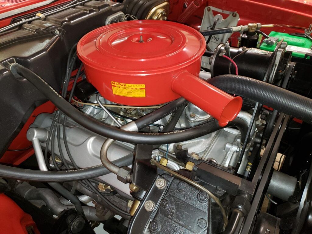 A vibrant 1960 Dodge Dart Phoenix Convertible gleams under soft lighting. Its bold fins, chrome trim, and open-top design scream classic American style.